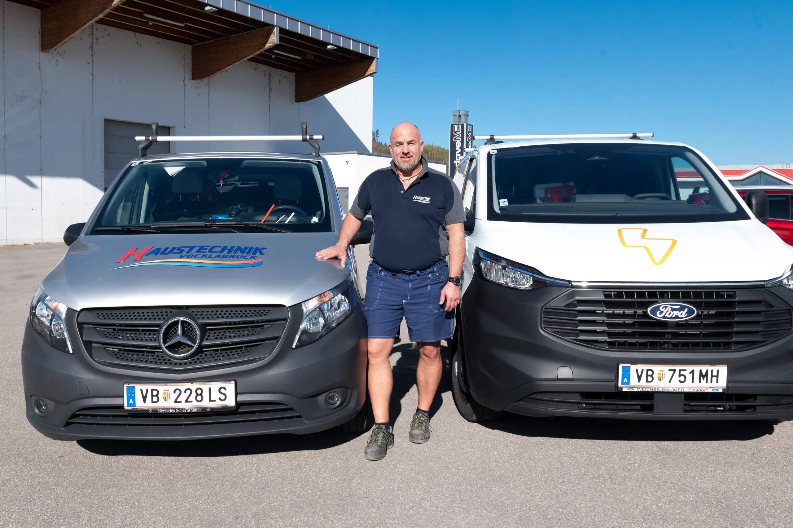Montageteam von Haustechnik Vöcklabruck vor den Einsatzfahrzeugen