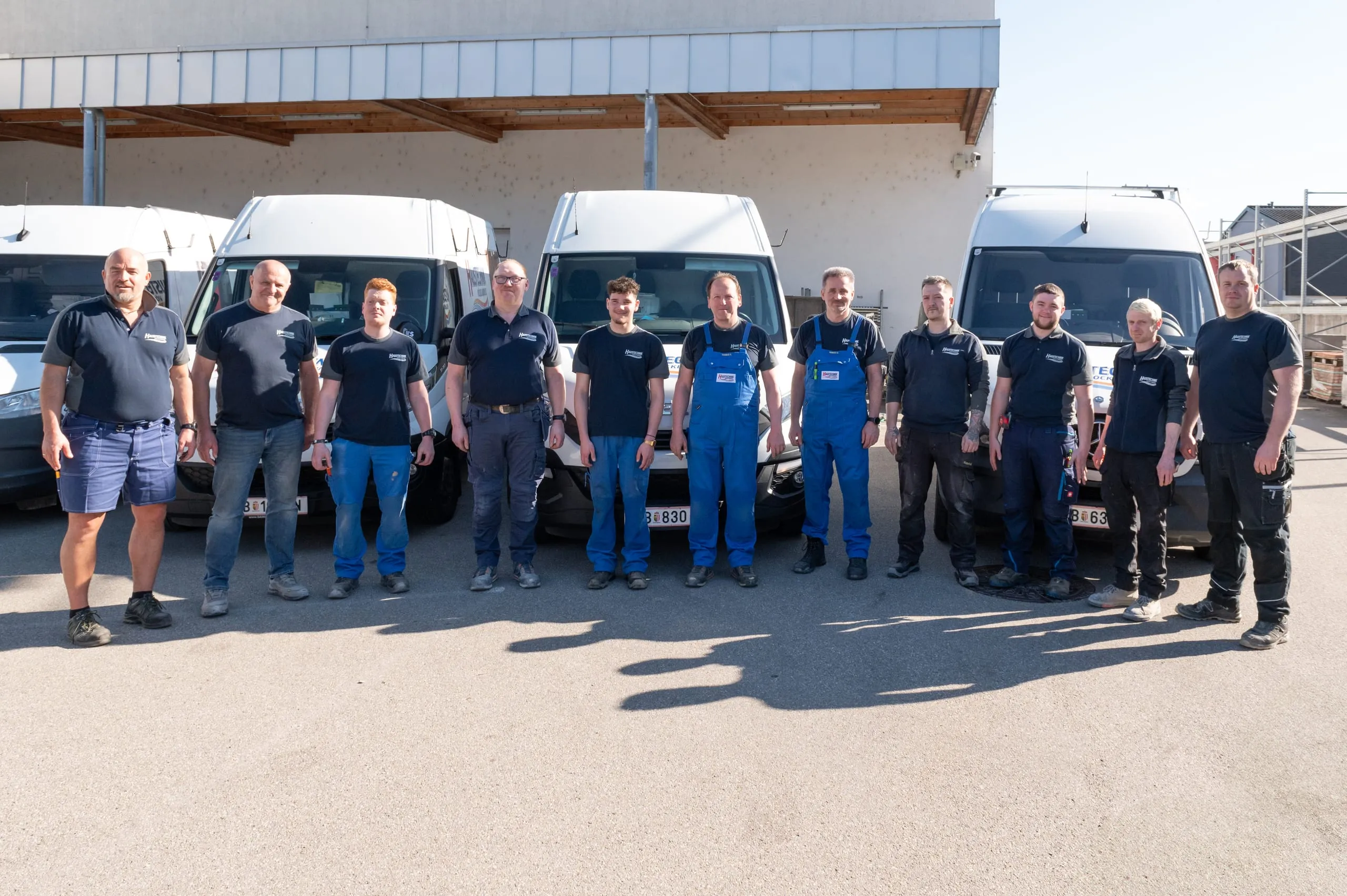 Montageteam von Haustechnik Vöcklabruck vor den Einsatzfahrzeugen